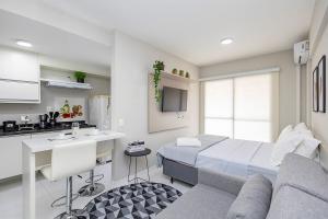 a hotel room with a bed and a kitchen at Edifício Champagnat Office in Curitiba