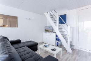 een woonkamer met een bank en een trap bij L'Echassier in Biscarrosse