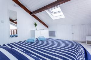 een slaapkamer met een blauw en wit gestreept bed bij L'Echassier in Biscarrosse