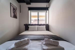 a bed with two pillows in a room with a window at Saga - Cinema Room in Chagny