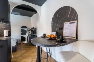 a small black table in a room with a kitchen at Saga - Cinema Room in Chagny +15 photos