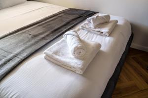 a bed with white towels on top of it at Saga - Cinema Room in Chagny