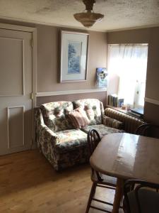 罗贝瓦勒Chez Odette, suite international的客厅里有一张沙发和一张桌子。