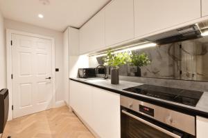 a kitchen with white cabinets and a stove top oven at Apartment 3 in York