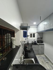 een keuken met een spoelbak en een aanrechtblad bij Guhan HomeStay- 2BHK Serviced Apartments - Full Furnished & Full Kitchen, WiFi & Balcony in Hyderabad