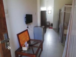 New Hotel Bundala park في تيساماهاراما: غرفه فيها كرسي وتلفزيون في غرفه