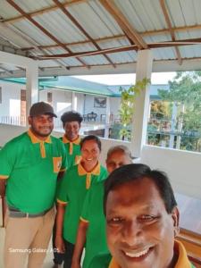 New Hotel Bundala park في تيساماهاراما: مجموعة من الرجال يرتدون قمصانًا خضراء يلتقطون صورة