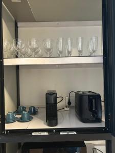 a shelf with wine glasses and a toaster on it at Aqua Aura 2 Bedroom Apartment Pereybere in Pereybere