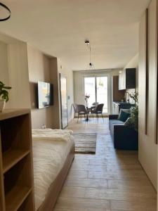 a room with a bed and a living room with a couch at The Rue in Il-Gżira