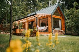 a cabin in the woods with a chair in it at Tiny house nad potokiem in Sidzina