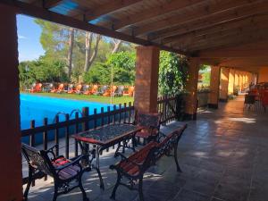 General AchaにあるHotel A Puro Campoのプールの横にあるベンチとテーブルのあるパティオ