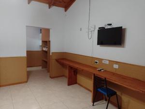 General AchaにあるHotel A Puro Campoの机と壁にテレビが掛かっている部屋