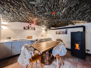 Una cocina con una mesa de madera con plumas en los techos. en La Volta di Champoluc - Poluc Apartments Monolocale, en Champoluc