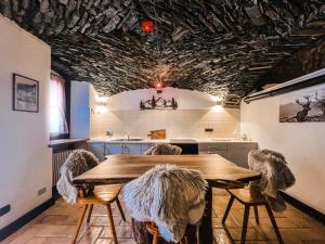 Una cocina con una mesa y sillas de madera. en La Volta di Champoluc - Poluc Apartments Monolocale, en Champoluc
