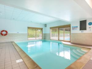 a large swimming pool with blue water at Résidence Vacancéole - Le Birdie in Giez