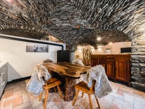 Un comedor con una mesa de madera con pelos de animales en sus sillas. en La Volta di Champoluc - Poluc Apartments Monolocale, en Champoluc 2 fotos más