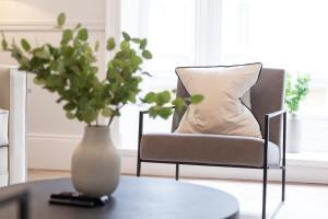 a chair with a pillow and a vase on a table at Apartment 3 in York