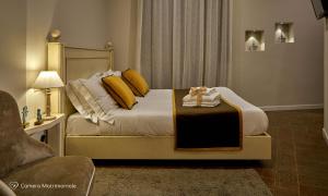 ein Schlafzimmer mit einem großen Bett mit gelben Kissen in der Unterkunft Albergo Diffuso Birkin Castello in Cagliari