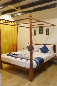 SeaFORT Beach Resort في Murūd: غرفة نوم بسرير مع اطار سرير خشبي