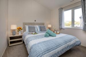 a bedroom with a bed with a blue comforter and a window at Sea Dreams, Riviera Bay - Brixham in Brixham +73 photos