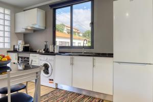 eine Küche mit weißen Schränken und einem Geschirrspüler in der Unterkunft Casa dos Anjos, a Home in Madeira in Lombo Galego + 16 Fotos