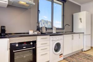 eine Küche mit Waschmaschine und Trockner in der Unterkunft Casa dos Anjos, a Home in Madeira in Lombo Galego