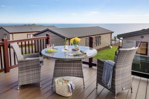 a patio with a table and chairs on a deck at Sea Dreams, Riviera Bay - Brixham in Brixham