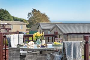 a glass table on a balcony with food on it at Sea Dreams, Riviera Bay - Brixham in Brixham