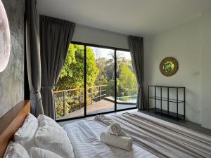 a bedroom with a bed with a large window at DeerWood villa in Hinkong