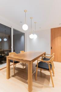 a dining room with a wooden table and chairs at 美瑛の一棟貸切古民家 - Nature Retreat Ubaku Villa in Biei