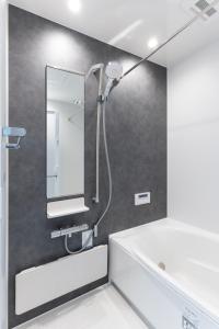 a bathroom with a shower with a mirror at 美瑛の一棟貸切古民家 - Nature Retreat Ubaku Villa in Biei