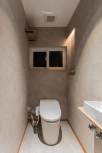 a bathroom with a toilet and a sink at 美瑛の一棟貸切古民家 - Nature Retreat Ubaku Villa in Biei +57 photos
