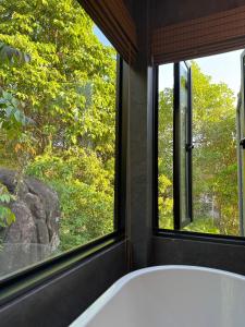 a bath tub in a room with two windows at DeerWood villa in Hinkong