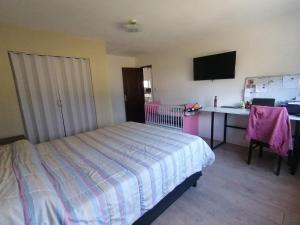 una camera da letto con un letto e una scrivania con un computer di La Esquina a Punta del Este