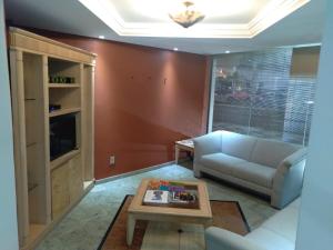 a living room with a couch and a coffee table at Hotel Santa Fé in Ponta Grossa