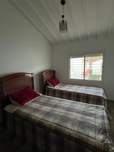 Un dormitorio con dos camas y una ventana. en Chalet cosy familial à Imouzzer - calme, nature et confort, en Imouzzer Kandar