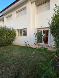 una casa blanca con césped delante en Chalet cosy familial à Imouzzer - calme, nature et confort, en Imouzzer Kandar