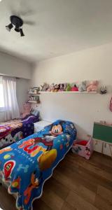 Casa Chauvin con pileta في مار ديل بلاتا: غرفة نوم بها سرير ميكي وألعاب على رف +13 صورة