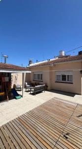 Casa Chauvin con pileta في مار ديل بلاتا: فناء منزل به سطح خشبي
