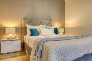 ein Schlafzimmer mit einem großen Bett mit blauen und weißen Kissen in der Unterkunft Casa dos Anjos, a Home in Madeira in Lombo Galego