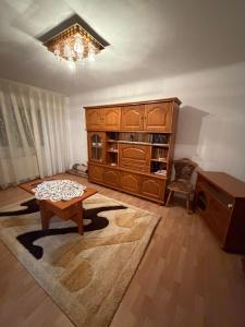 a living room with a large wooden cabinet and a table at Apartament in Craiova in Craiova +8 photos