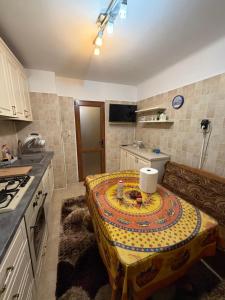 a kitchen with a table in the middle of it at Apartament in Craiova in Craiova