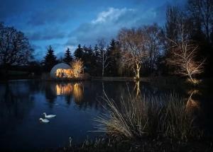 a domed building on a lake at night at Domaine des Pins L'île au Dôme in Grundviller
