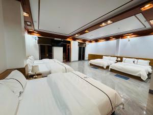 a room with four beds and a large mirror at Phương Anh Hotel in Mèo Vạc