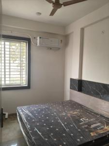 een bed in een kamer met een plafondventilator bij Aarav Home in Indore