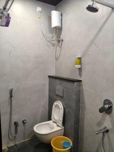 een kleine badkamer met toilet en douche bij Aarav Home in Indore