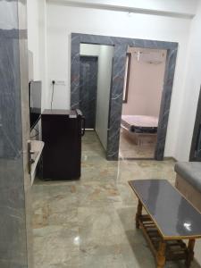 een kamer met een bed, een tafel en een spiegel bij Aarav Home in Indore