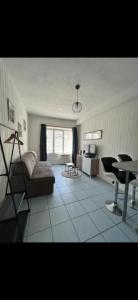 ein Wohnzimmer mit Sofa und Tisch in der Unterkunft Le petit studio Rue de l'Imprimerie in Gap