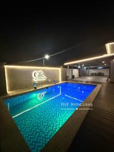 Gfe Home Villa Swimming Pool 20Pax 5Bedroom في ماساي: مسبح كبير في مبنى في الليل