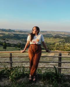 a woman standing on top of a fence at Glamping & country house Marche Nascoste Gualdo in San Girolamo di Sopra